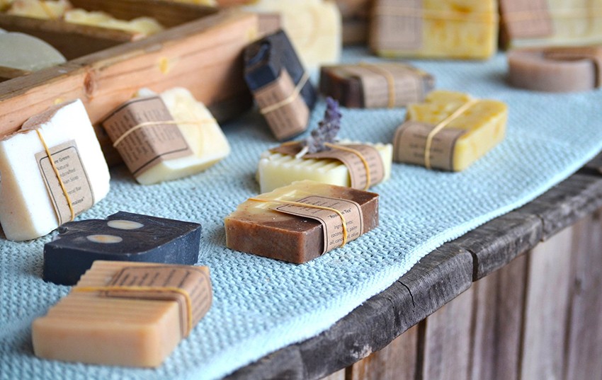 Handmade soaps wrapped in brown paper on a craft market table